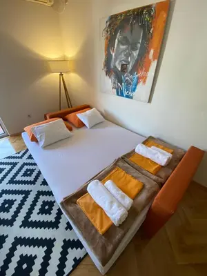 a hotel room with a bed with towels on it at Apartman Filip in Podgorica