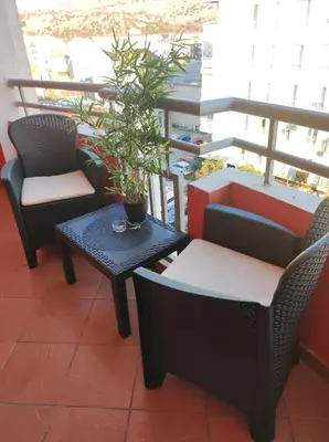 a balcony with chairs and a table and a potted plant at Apartman Filip in Podgorica
