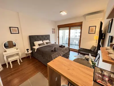 a bedroom with a bed and a living room at White Homes 16 - Master Quart in Podgorica