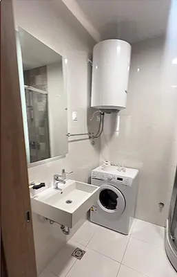 a bathroom with a sink and a washing machine at White Homes 16 - Master Quart in Podgorica