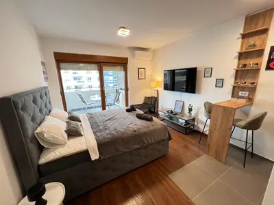 a bedroom with a bed and a living room at White Homes 16 - Master Quart in Podgorica