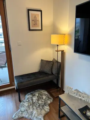 a living room with a bench and a tv at White Homes 16 - Master Quart in Podgorica