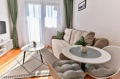 a living room with a couch and a table and chairs at Sonja Apartment in Budva