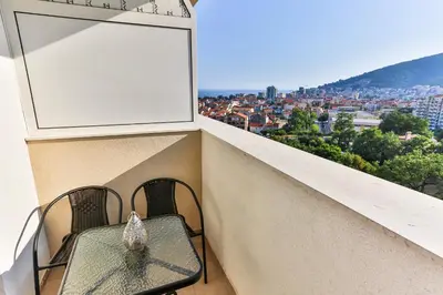 a table and chairs on a balcony with a view at Sonja Apartment in Budva