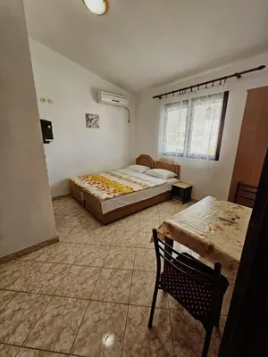 a bedroom with a bed and a table and a chair at Apartmani MIM in Bar