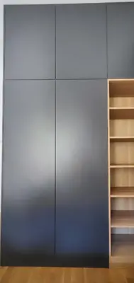 a closet with a metal door and wooden shelves at Cozy One-Bedroom Apartment at Ljubovic Park in Podgorica