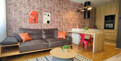 a living room with a couch and a brick wall at Cozy One-Bedroom Apartment at Ljubovic Park in Podgorica