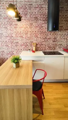 a kitchen with a table and a red chair at Cozy One-Bedroom Apartment at Ljubovic Park in Podgorica