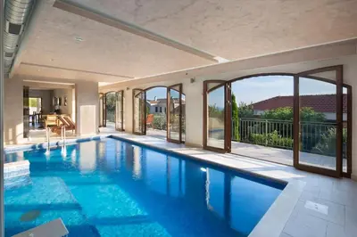 a swimming pool with a view of a house at Villa Gradina in Budva