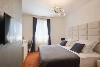 a hotel room with a large bed and a television at Villa Gradina in Budva