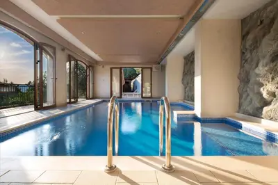 a swimming pool in a house with glass doors at Villa Gradina in Budva