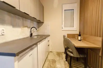 a small kitchen with a sink and a table at Apartments Posejdon Lux in Utjeha