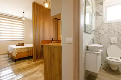 a bathroom with a toilet and a bedroom with a bed at Apartments Posejdon Lux in Utjeha