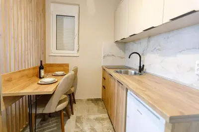 a kitchen with a wooden counter top and a sink at Apartments Posejdon Lux in Utjeha
