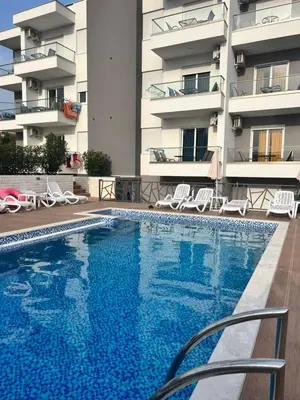 a swimming pool in front of a building at Apartments Posejdon Lux in Utjeha