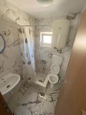 a white bathroom with a toilet and a sink at Sun-Love in Sutomore