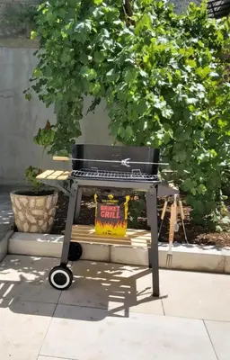 a grill with a sign on it sitting on a sidewalk at Apartment Marina in Kotor