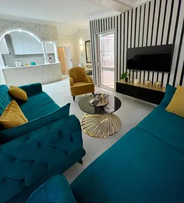 a living room with a blue couch and a tv at Budva house Maja in Budva