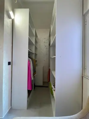 a walk in closet with white walls and a mirror at Budva house Maja in Budva