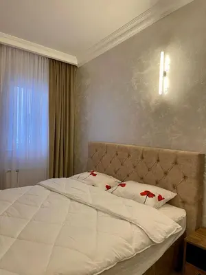 a bedroom with a white bed with red flowers on it at Budva house Maja in Budva