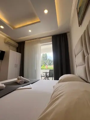 a hotel room with a bed and a large window at Apartments Fati & Flori in Ulcinj