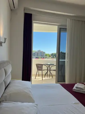 a bedroom with a bed and a balcony with a table at Apartments Fati & Flori in Ulcinj
