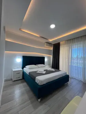 a bedroom with a large bed and a window at Apartments Fati & Flori in Ulcinj