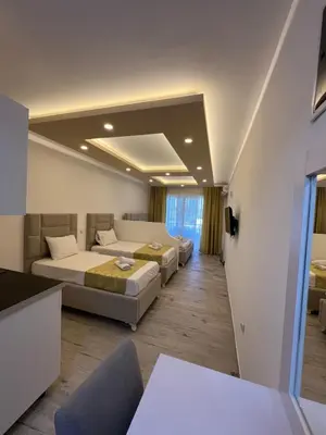 a hotel room with two beds and a couch at Apartments Fati & Flori in Ulcinj