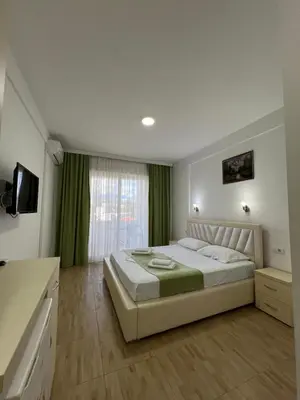 a bedroom with a large bed and a window at Apartments Fati & Flori in Ulcinj