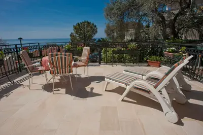 a patio with rocking chairs and a table and chairsktop at Apartments Marina in Sveti Stefan
