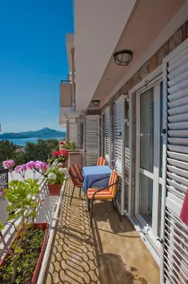 a balcony with a blue table and chairs on it at Apartments Marina in Sveti Stefan