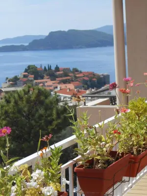 a balcony with flowers and a view of the water at Apartments Marina in Sveti Stefan