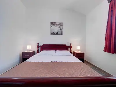 a bedroom with a large bed with two night stands at Apartments Marina in Sveti Stefan