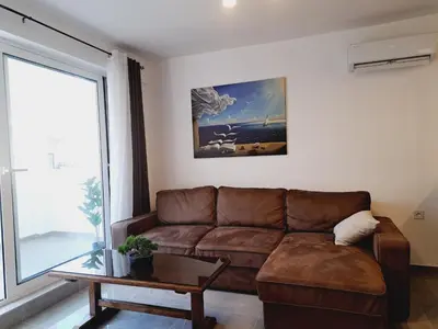 a living room with a brown couch and a table at Paun apartment in Kotor