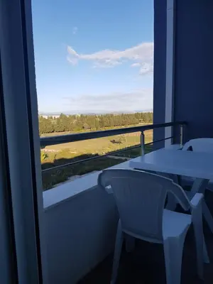 a balcony with a table and a view of a field at Dina & Dona in Ulcinj