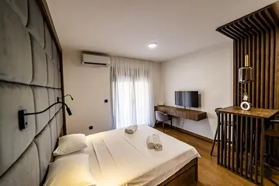 a hotel room with a bed and a television at Apartments Tulip Podgorica in Podgorica