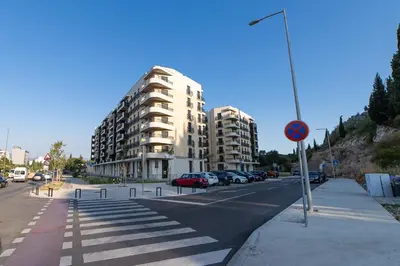 a street with cars parked on the side of a building at Apartments Tulip Podgorica in Podgorica