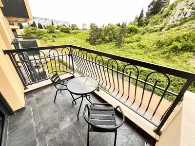 a balcony with a table and chairs and a view at Apartments Tulip Podgorica in Podgorica