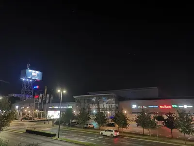 a shopping center at night with a lit up sign at Delta Apartman in Podgorica