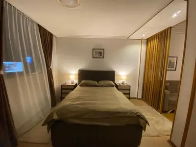 a bedroom with a large bed and two lamps at Delta Apartman in Podgorica
