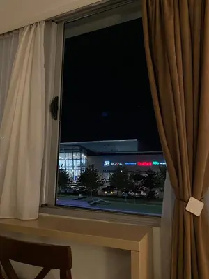 a window with a view of a city at night at Delta Apartman in Podgorica