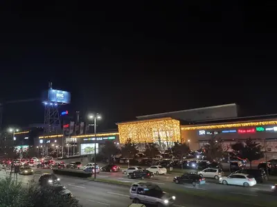 a parking lot with cars parked in front of a building at Delta Apartman in Podgorica