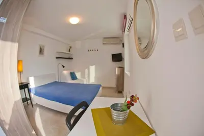 a room with a bed and a table with a mirror at Apartments Mandarina Garden in Petrovac na Moru
