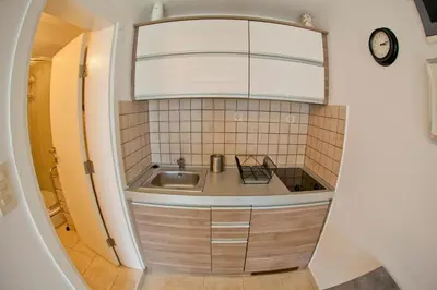 a small kitchen with a sink and a mirror at Apartments Mandarina Garden in Petrovac na Moru