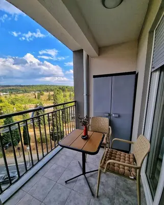 a balcony with a table and chairs and a view at Riverside Apartment in Podgorica