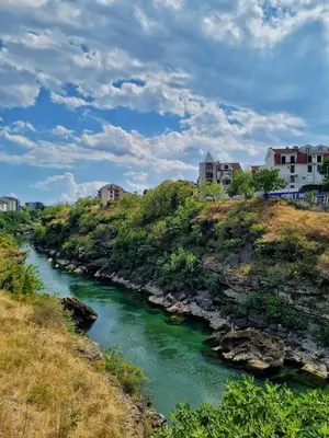 a river with houses on top of a hill at Riverside Apartment in Podgorica