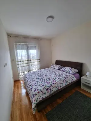 a bedroom with a large bed with pillows on it at Riverside Apartment in Podgorica