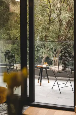 a patio with two chairs and a table in front of a window at ZAFIRO SPA & RESIDENCE in Budva