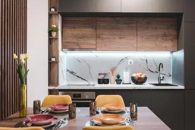 a kitchen with a wooden table with chairs and a sink at ZAFIRO SPA & RESIDENCE in Budva