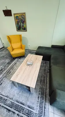 a living room with a coffee table and a yellow chair at Apartmani Green Olive in Bar, Susanj